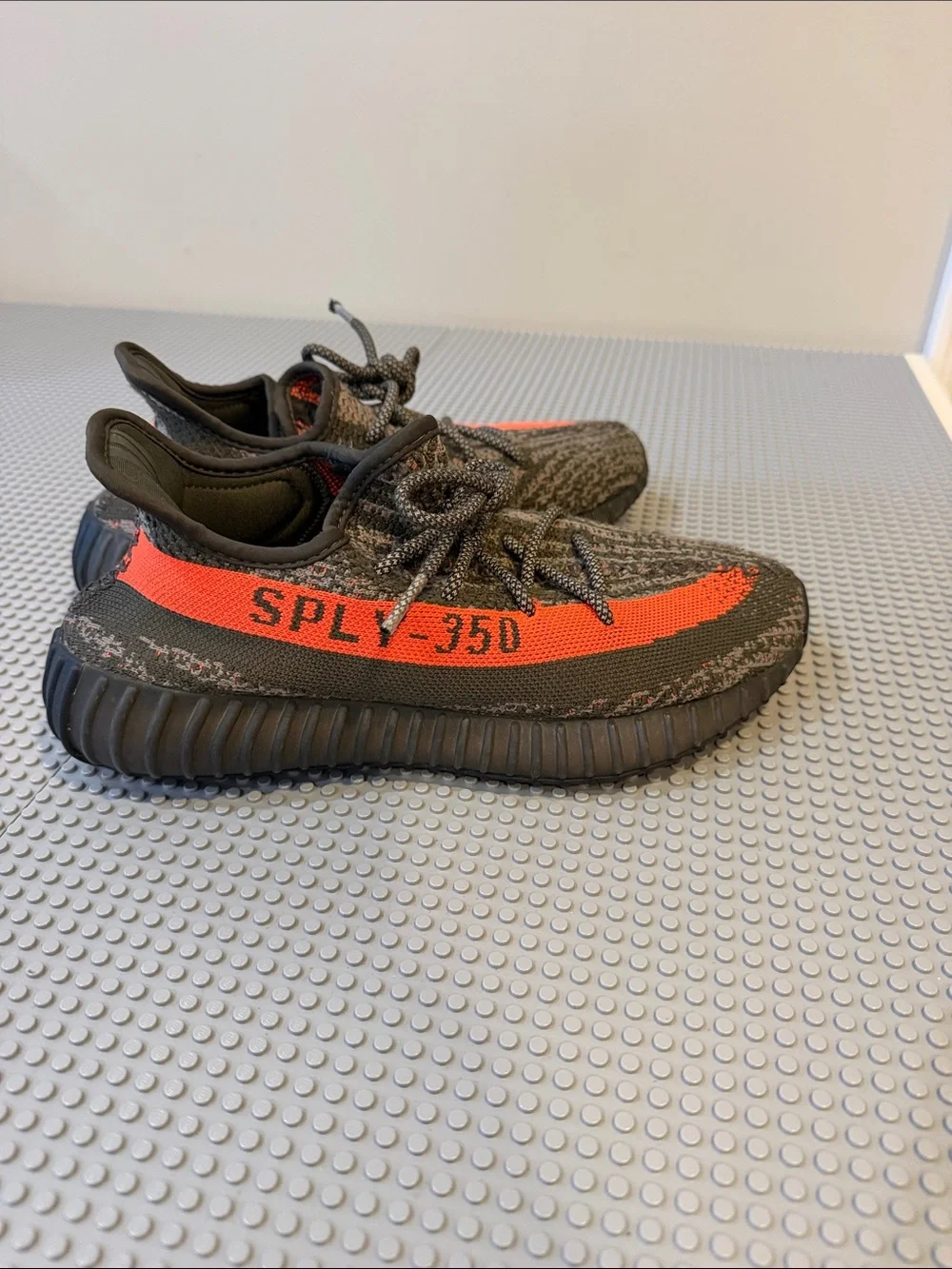 Yeezy men’s Black Knit Sneakers with Bright Orange Stripe